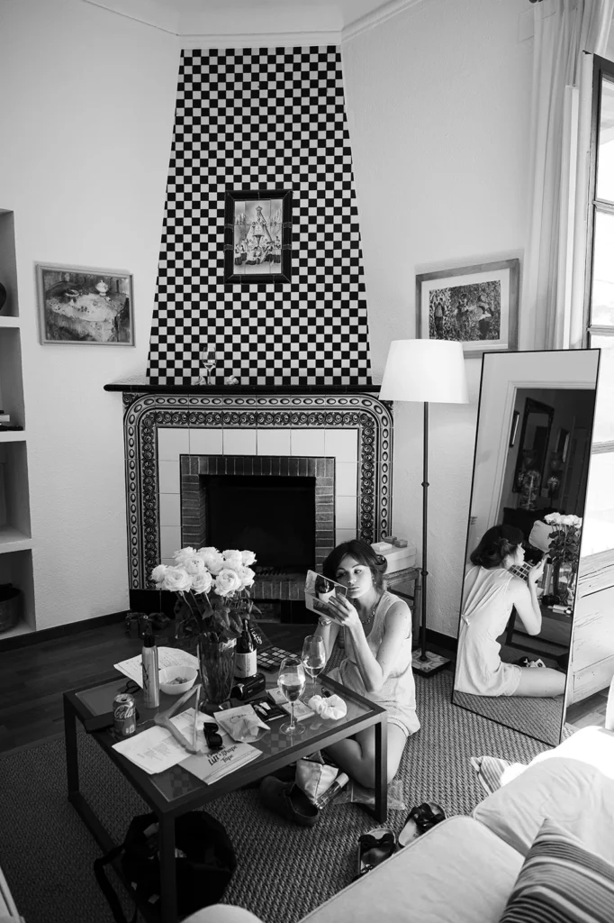 Documentary wedding photography at Mas Palou: bride sitting on the floor during makeup session in black and white