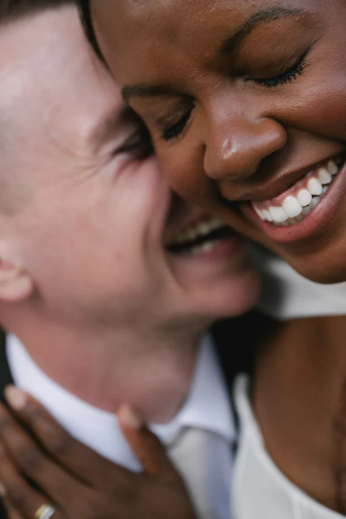 Candid wedding photography: bride laughing as groom embraces her. Emotional storytelling portrait by Jessica North in Mallorca