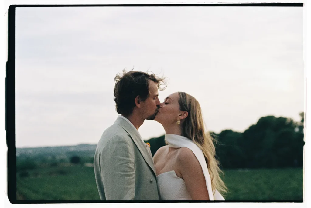 Intimate analog film portrait of a bride and groom kissing in a Mediterranean field by Jessica North.