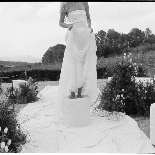 Editorial black and white wedding photography of a bride standing on a pedestal surrounded by artistic tulip installations by Jessica North.